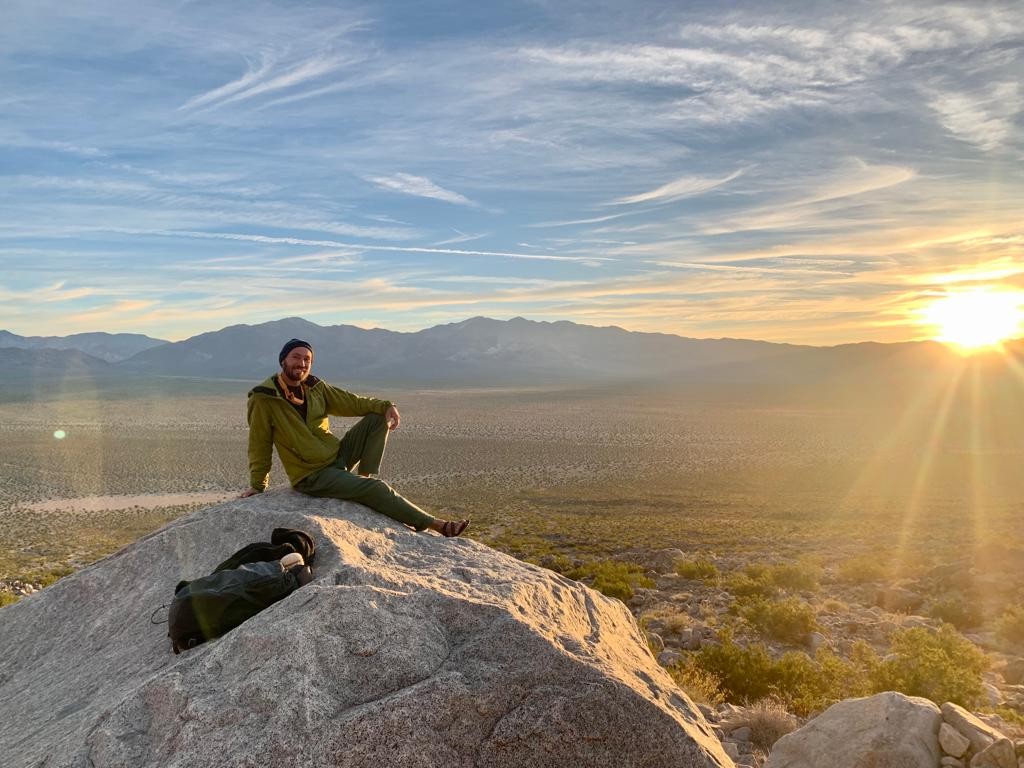 Tommy seated on a broad rock in warm evening light