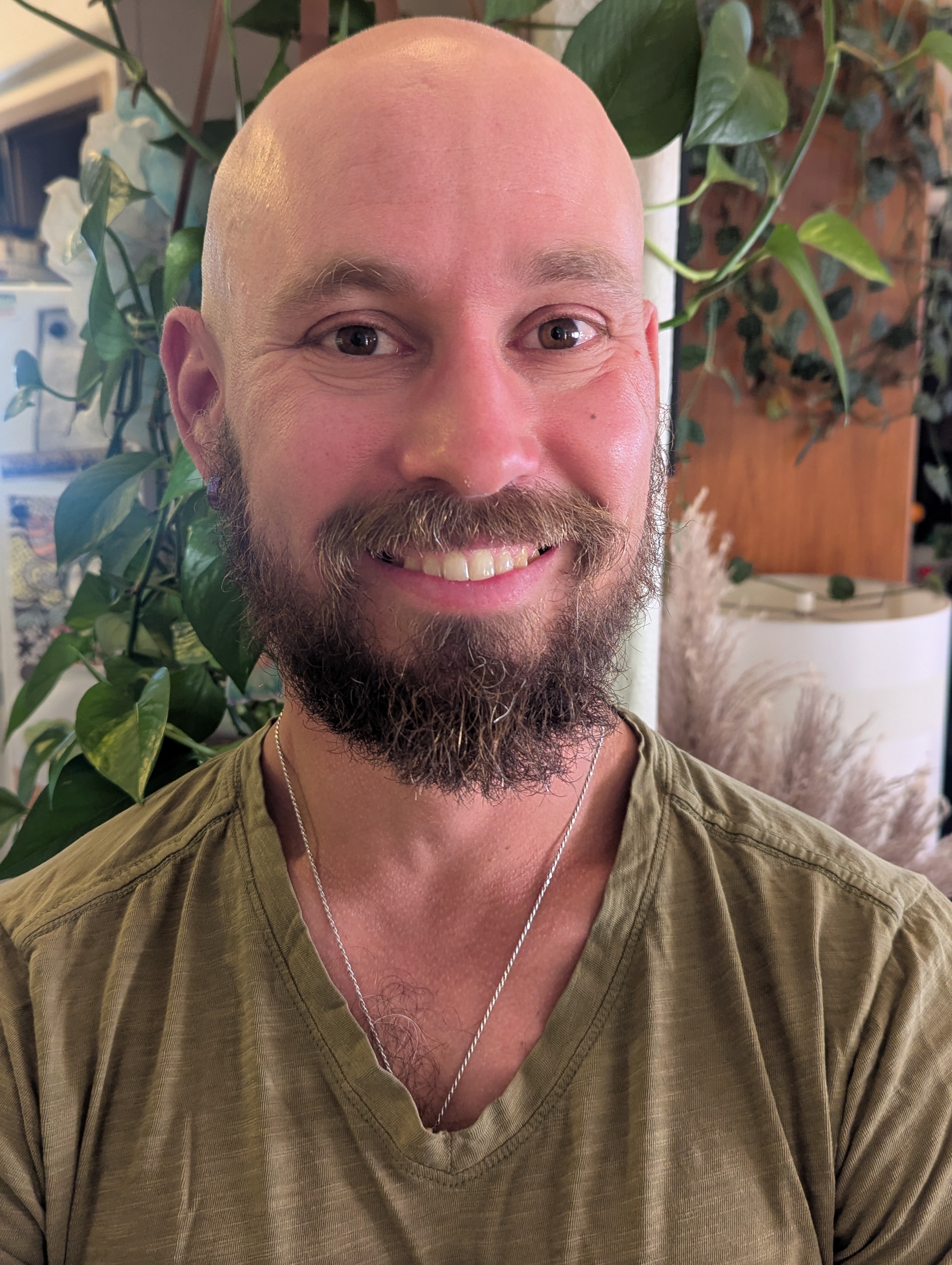 Tommy smiling in a plant-filled room